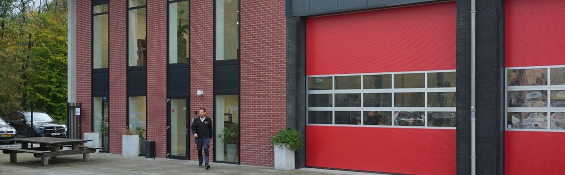 man loopt buiten voor een bedrijfsgebouw