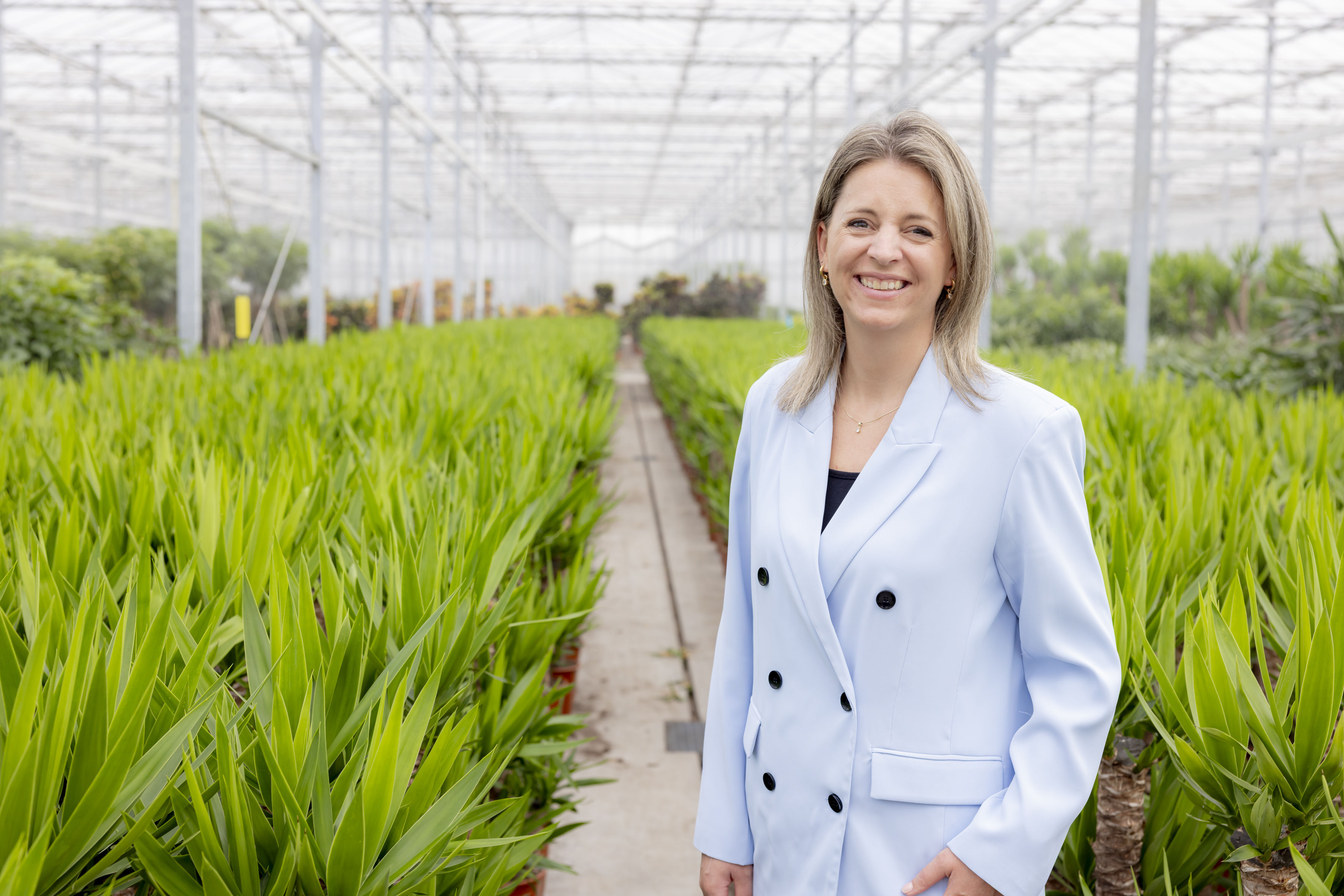 Ivana Dekker staat in een kas tussen de planten
