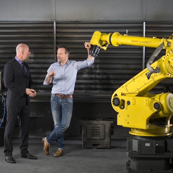 Twee mannen naast elkaar in een fabriek