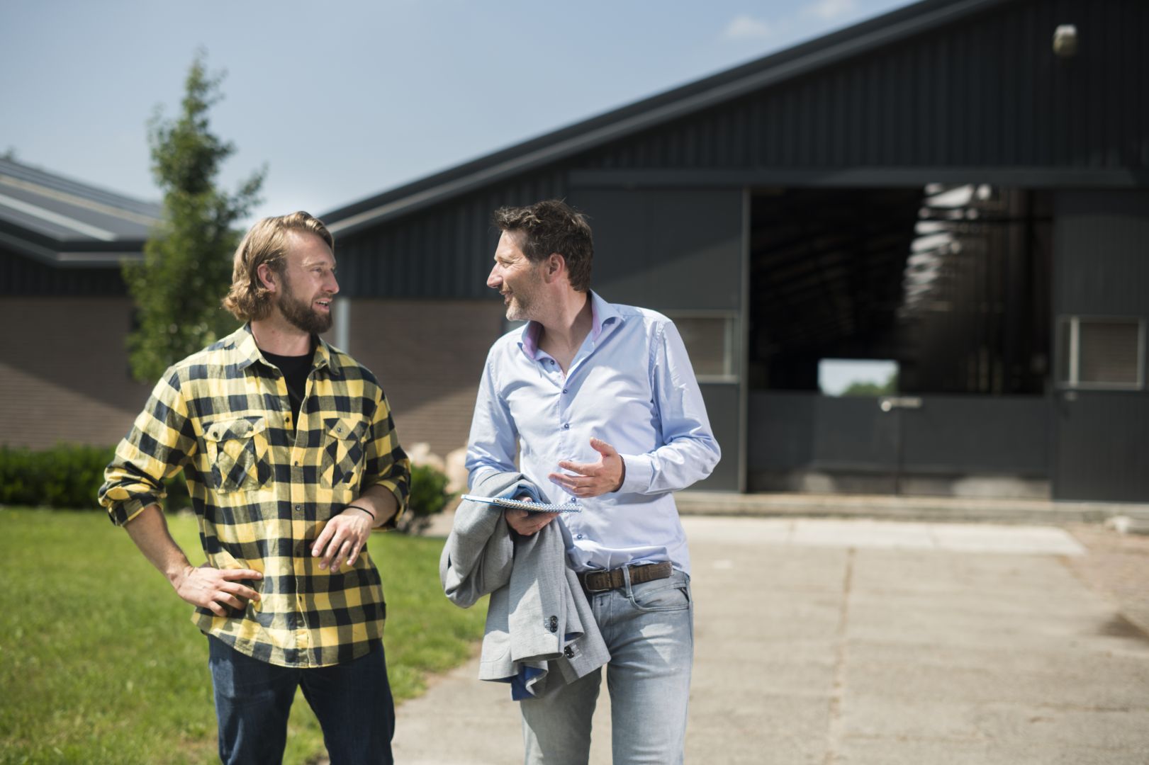Adviseur en ondernemer staan voor schuur