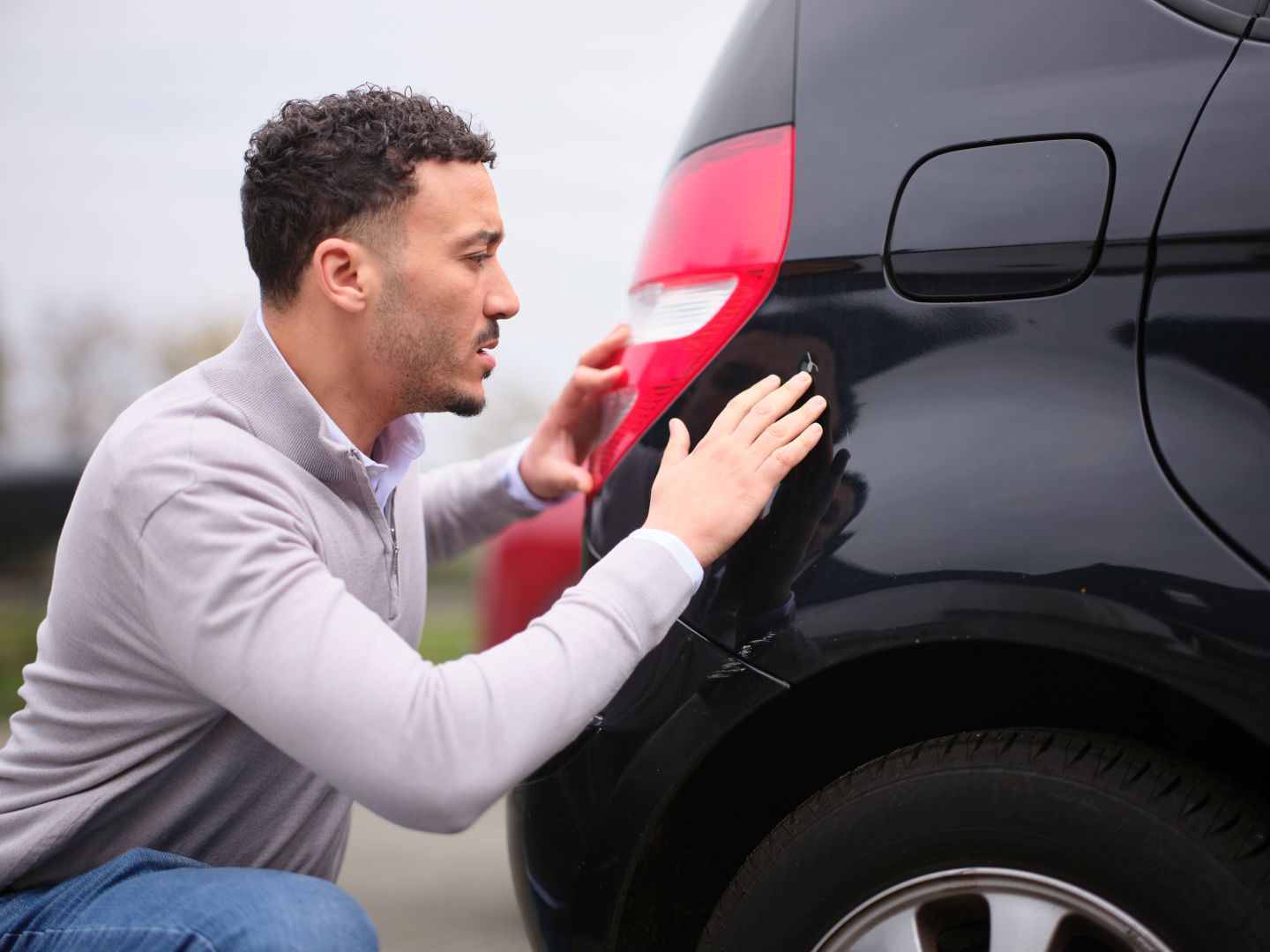Man bekijtk schade aan auto