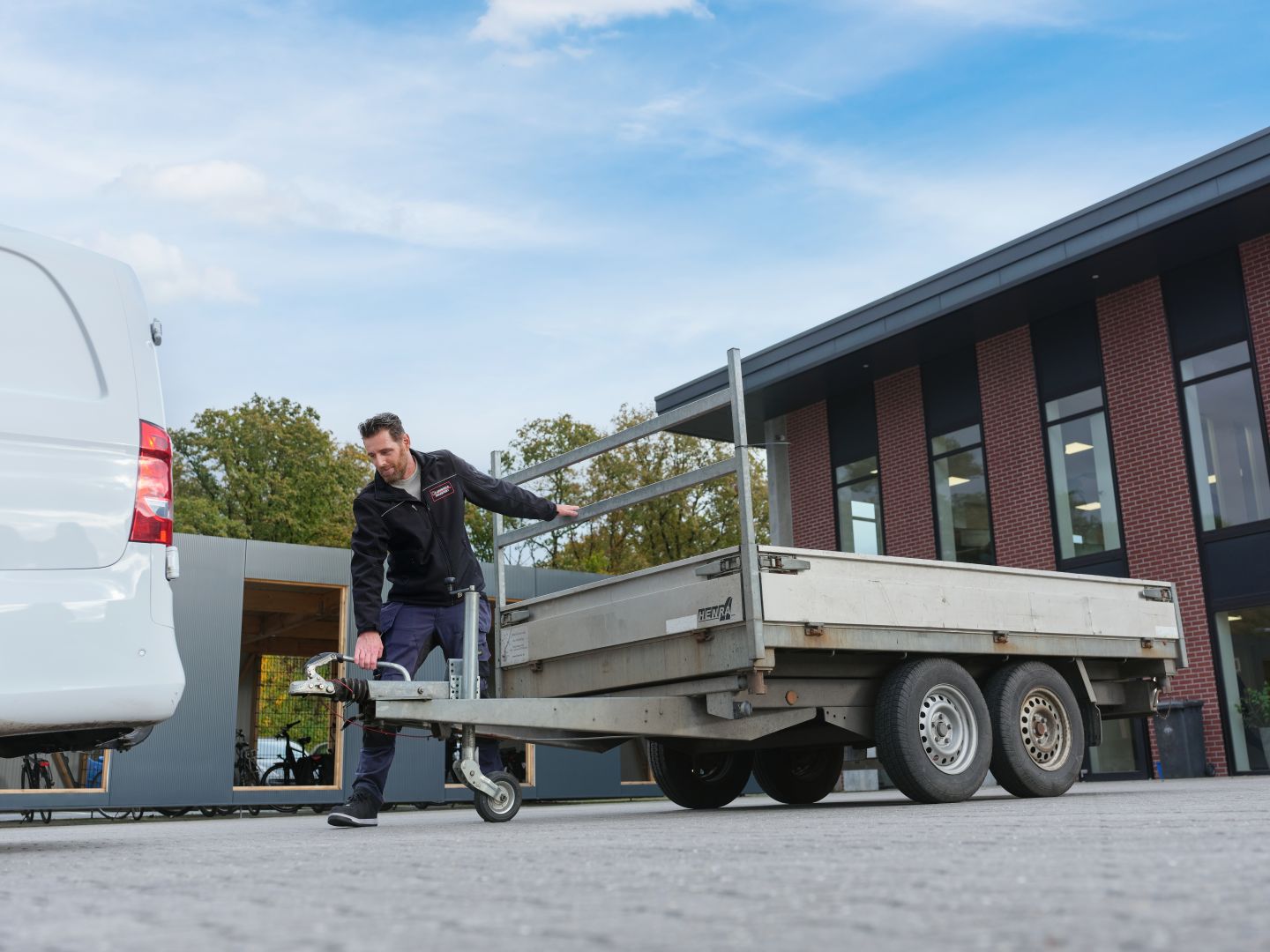 Man koppelt aanhanger aan auto