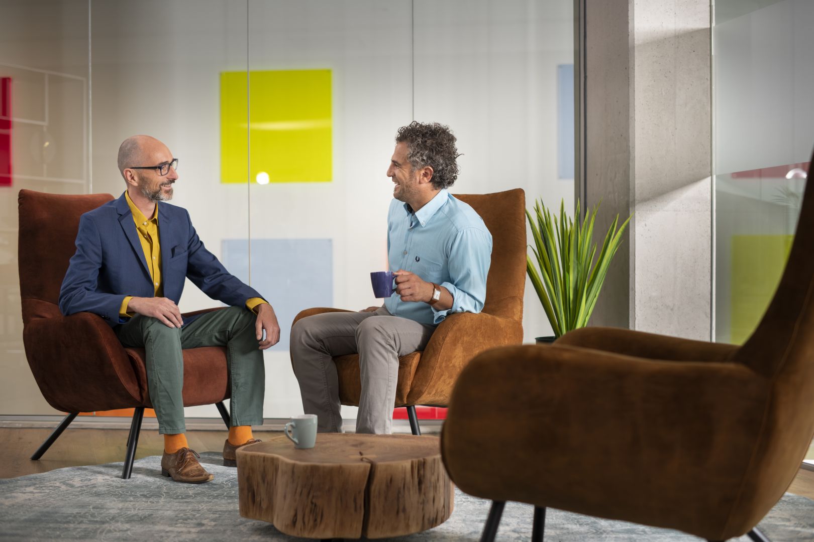 Twee mannen overleggen en zitten op stoelen