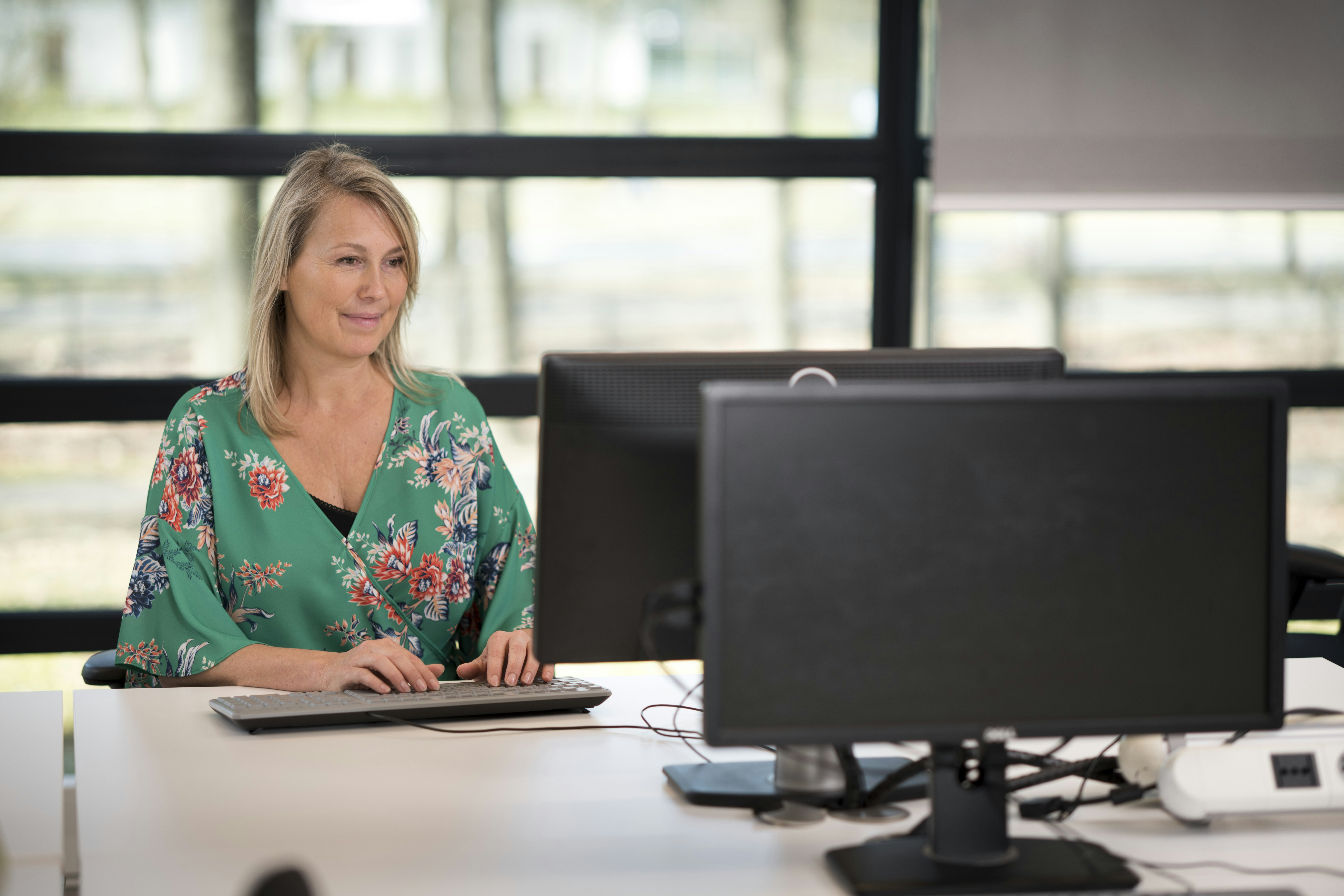 Vrouw achter laptop typt op toetsenbord