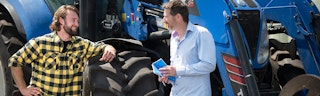 Adviseur geeft advies over agrarische gebouwenverzekering bij tractor