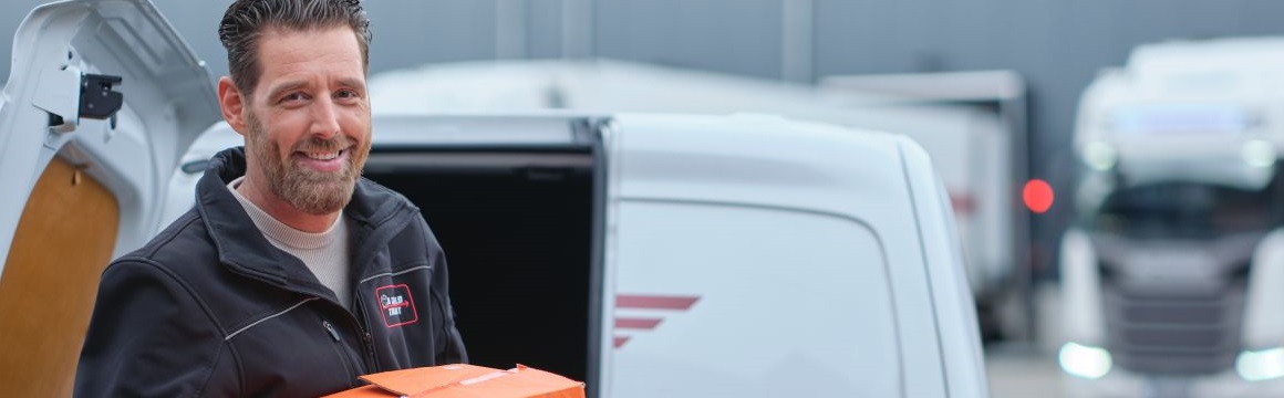 man aan het uitladen bij bestelauto