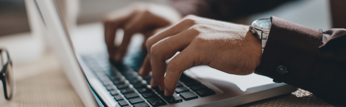 handen aan het typen op laptop