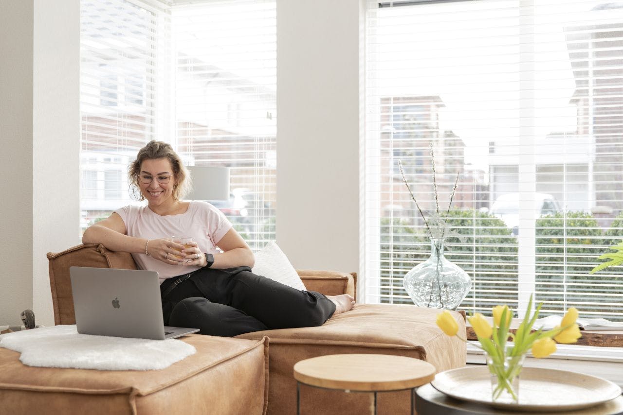 Vrouw met laptop op bank