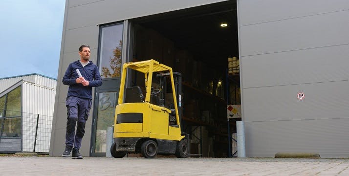 man loopt naar buiten vanuit magazijn